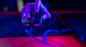 a hand clicking a computer mouse in a dark room