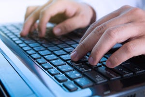 hands typing on laptop keyboard