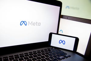 Meta logo on laptop and smartphone screens